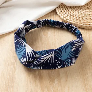 Detailopname van de blauw-witte bedrukte stoffen haarband met bladerenprint voor de zomer.