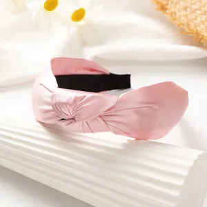 Pink knotted headband detail closeup, soft satin hair hoop accessory for women and girls daily wear.