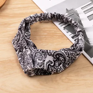 Detailaufnahme des schwarz-weißen Paisley-Haarbandes aus weichem Satin mit verdrehtem Design.