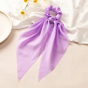 Vue détaillée d'un chouchou à longs rubans en satin violet, style doux et élégant au quotidien.