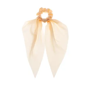 Gros plan détaillé d'un chouchou en satin doux avec de longs rubans, accessoire de coiffure.