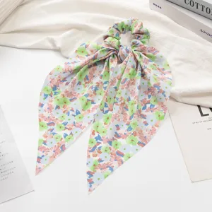 Vue détaillée d'un chouchou à cheveux floral de style coréen avec de longs rubans en tissu.