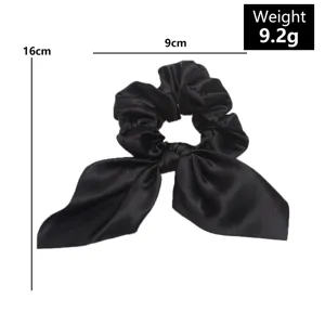 Black satin hair scrunchie with long streamer bow, elegant solid color hair accessory detail.