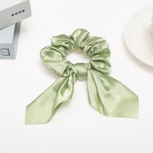 Light green satin hair scrunchie with cute ribbon bow tail, elegant women ponytail holder accessory.