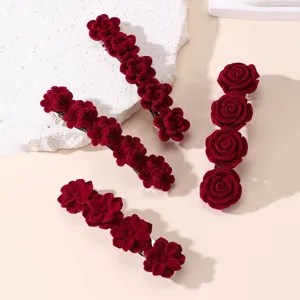 Close-up opname toont details van rode fluwelen roos bloem haarspelden en klemmen accessoires.