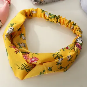 Bandeau en tissu à imprimé floral jaune avec nœud torsadé, accessoire de cheveux élégant pour femmes.