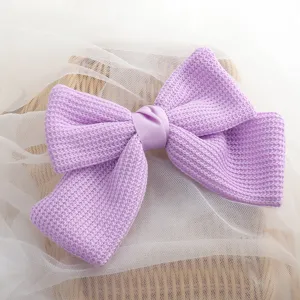 Close-up detail of a charming light purple woven bow hair clip with soft fabric texture.