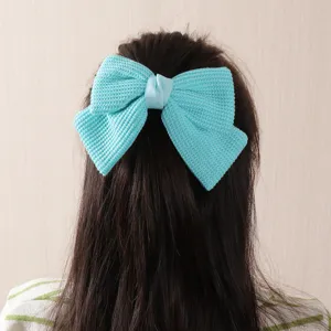 Blue knit bow hair clip detail, cute fabric hair accessory for women and girls.