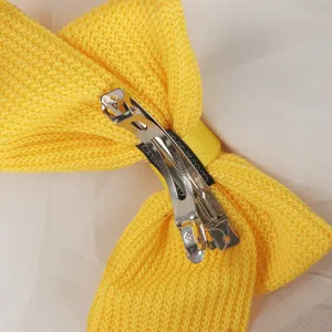 Yellow knitted bow hair clip detail view, cute hair accessory with metal spring barrette.