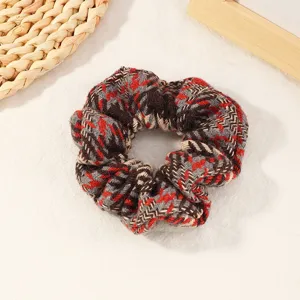 Plaid fabric hair scrunchie for women, cute winter hair tie and ponytail holder accessory.