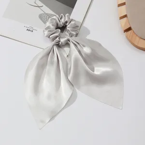 Close-up detail of the elegant silver satin hair scrunchie with long ribbon streamers.
