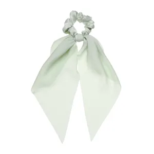 Primo piano dettagliato dell'elastico per capelli in satin verde chiaro con lunghi nastri.