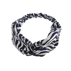 Close-up detail of stylish twist elastic headband with abstract animal print design.