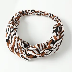 Close-up detail of the stylish twisted headband with abstract animal print pattern.