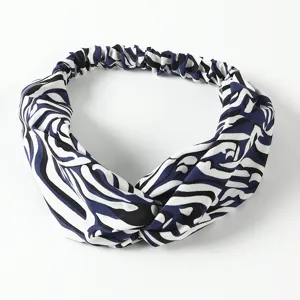 Close-up detail of the blue and white abstract print twist headband with elastic back design.