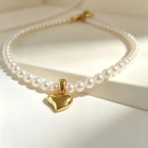 Close-up detail of the French vintage pearl necklace with a glossy gold heart pendant.