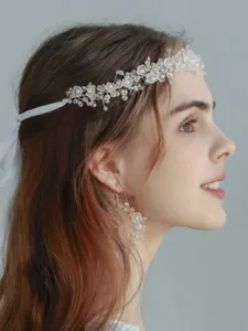 Elegant rhinestone pearl bridal hair vine and matching earrings detail shot for wedding.