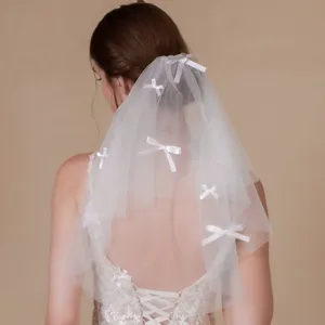 Elegant white double-layer bridal veil with cute bow accents for wedding and photo props.