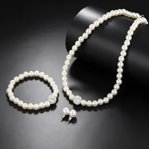 Close-up detail shot of the elegant pearl necklace and bracelet with sparkling rhinestone balls.