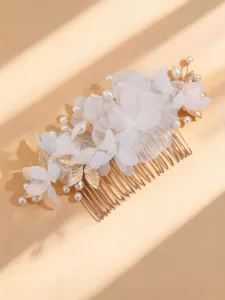 Detail view of the elegant gold bridal hair comb featuring white fabric flowers and pearls.