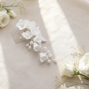Detailed view of handmade bridal hair comb with elegant white ceramic flowers and pearls.