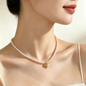 Close-up detail of a vintage pearl necklace with a gold heart pendant worn elegantly on neck.