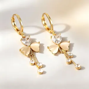 Delicate gold-plated drop earrings featuring sparkling heart-shaped zirconia and clover charms.