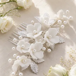 Handmade bridal hair comb with white ceramic flowers and pearls for wedding hair styling.