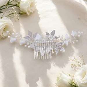 Close-up detail of the elegant silver bridal hair comb adorned with ceramic flowers and pearls.
