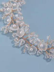 Close-up detail of crystal floral hair vine, handmade gold wire pearl bridal headpiece.