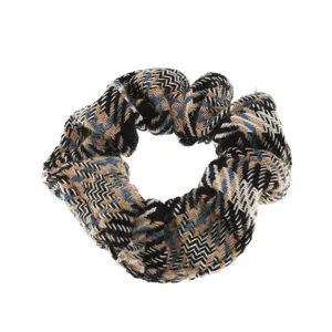 Cozy tweed hair scrunchie with classic herringbone pattern, stylish hair accessory for women.