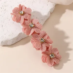 Pince à cheveux fleur rose élégante avec des pétales en tissu scintillant et strass.