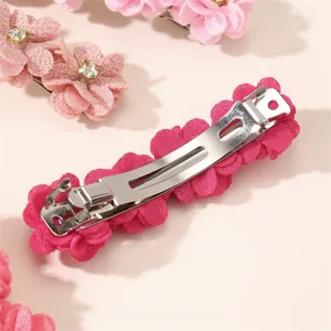 Vue détaillée de la jolie pince à cheveux en velours floral avec fermoir à ressort métallique.