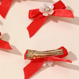 Red bow hair clip detail with white flower rhinestone center, elegant sweet hair accessory.