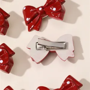 Detailed view of red polka dot bow hair clip with metal duckbill back design for women.
