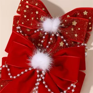 Rode fluwelen strik haarspeld detail, met witte pluche ballen en parelkettingen als haaraccessoire.