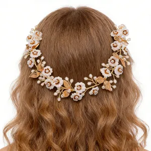 Detail view of a gold floral hair vine with white flowers and pearls worn on wavy hair.
