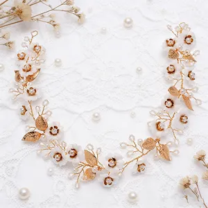 Elegant gold bridal hair vine with white flowers and pearls for wedding styling accessories.