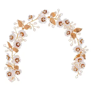 Elegant bridal floral hair vine with white flowers, pearls, and golden leaves for wedding.