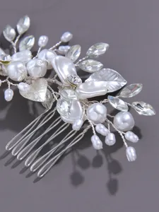 Detailed view of silver bridal hair comb with pearls, crystals, and metallic leaf accents.