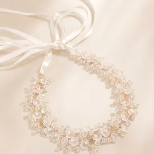 Elegant bridal hair vine with crystal flowers, pearls and white ribbons for wedding party.