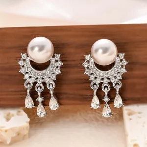 Vue détaillée de boucles d'oreilles pampilles perles strass minimalistes et zircons brillants.