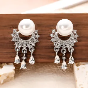 Gros plan de boucles doreilles perles strass franges, detail de metal argente fin.