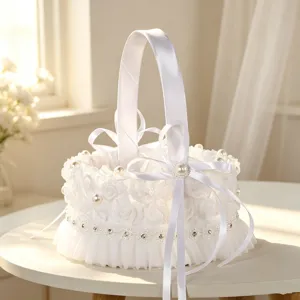 White wedding flower girl basket detail, lace pearl bow design, elegant tabletop decor.