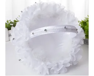 White wedding flower girl basket with lace, rhinestones, and feathers for bridal ceremony.