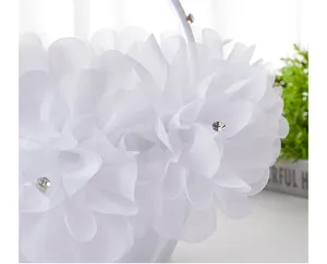 White wedding flower girl basket with delicate floral lace and shiny rhinestones for ceremony.
