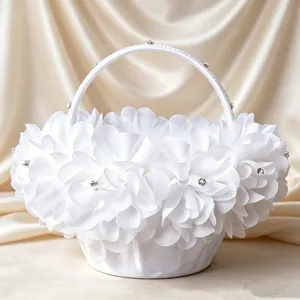 White flower girl basket with lace, rhinestones and fabric flowers for wedding ceremony.