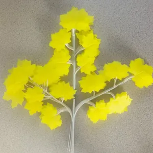 Artificial yellow maple leaf branch, plastic plant stem for home decor, floral arrangement detail.