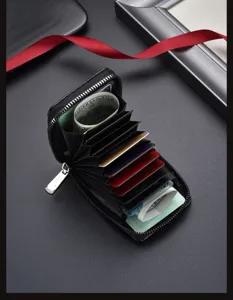Tarjetero con cremallera en fibra de carbono negra, diseño de acordeón y múltiples ranuras.