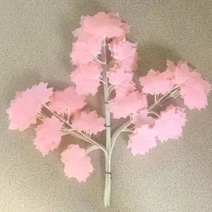 Pink artificial maple leaf branch decorative fake plant for home and party decoration.